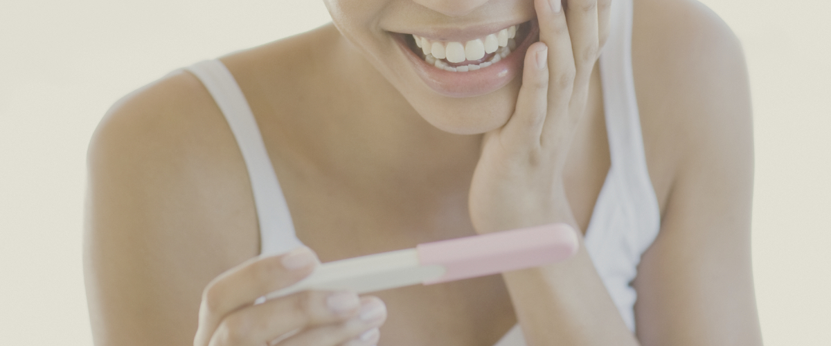 Happy woman looking at pregnancy test