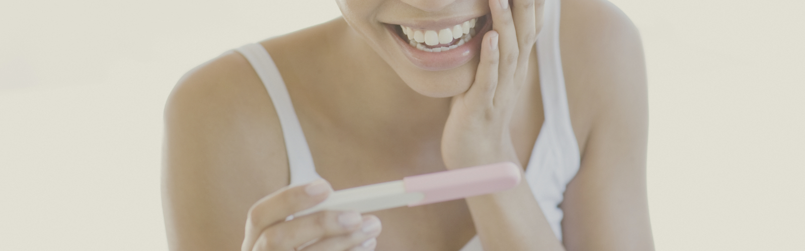 Happy woman looking at pregnancy test